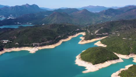 Camión-Aéreo-A-La-Izquierda-Del-Embalse-De-La-Isla-Alta-Playa-De-Arena-De-Agua-Turquesa-Costa-Y-Colinas-Verdes,-Península-De-San-Kung-En-Hong-Kong,-China