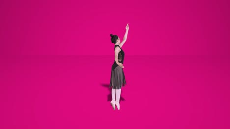 ballet dancer exercising on pink background