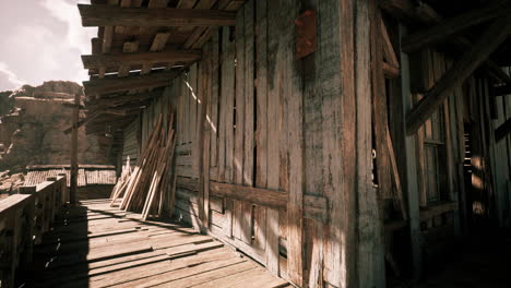 old wooden structure with sunlit shadows in a desolate area during the day