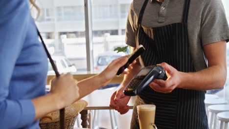 mujer pagando facturas a través de tecnología nfc