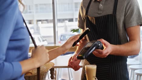 woman paying bill through nfc technology