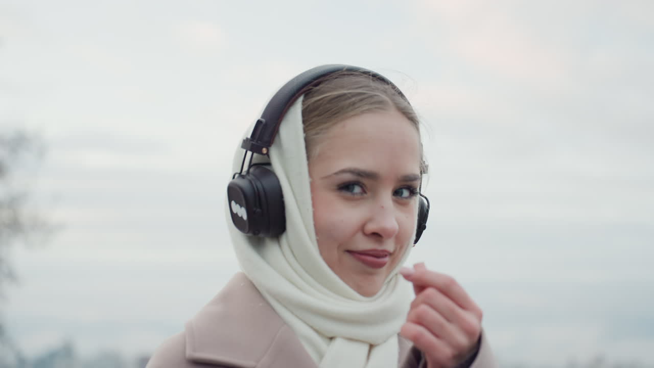 おしゃれで自信に満ちた女性。自信を醸し出すスタイリッシュな女性。落ち着いた雰囲気とほのかな輝きを見せるエレガントな女性。ヘッドホンとスカーフをアクセサリーにした、おしゃれで自信のある女性。