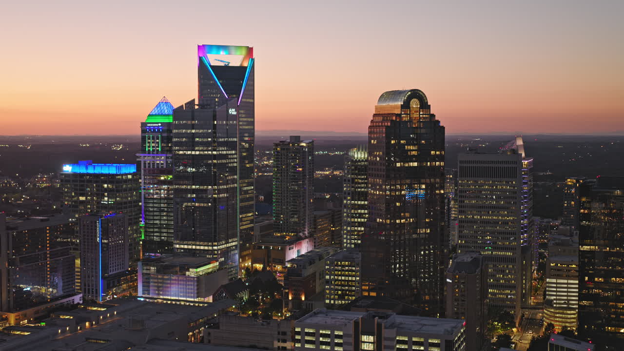 Charlotte North Carolina Aerial v83 flyover and around Second Ward, a bustling Uptown district capturing illuminated downtown cityscape against sunset dusk sky - Shot with Inspire 3 8k - Oct 1st 2023