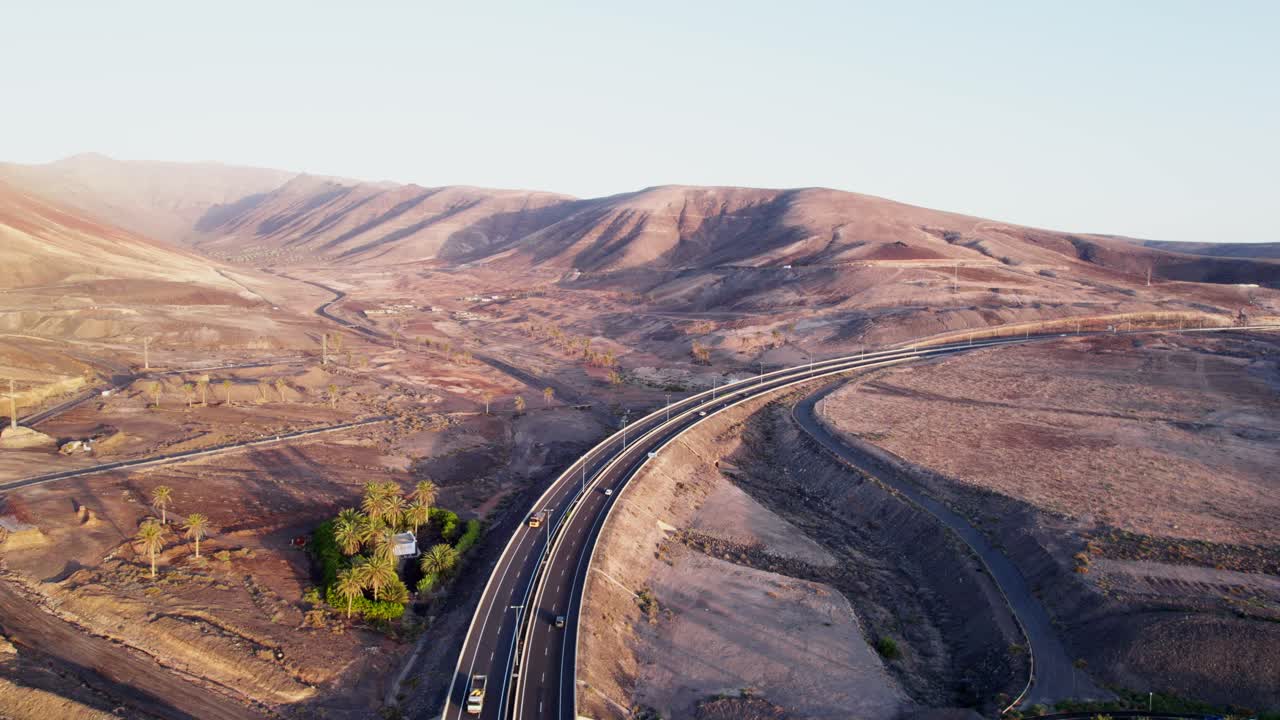푸에르테벤투라의 건조한 풍경에서 휘어지는 도로, 이른 아침 빛, 공중 풍경
