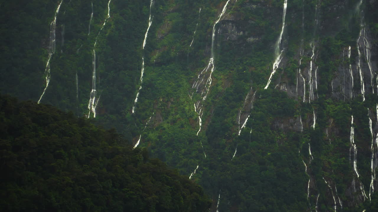 hermosa vista panorámica de las montañas con muchas cascadas después de la lluvia en millford sound, nueva zelanda