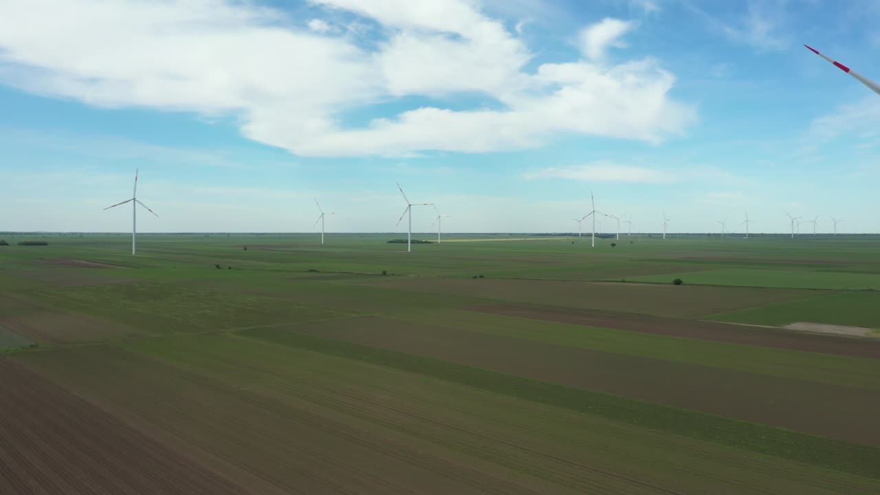 View of several windmills, wind generators, turbines, producing renewable clean energy by converting kinetic energy