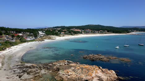 Luftlandschaftsumlaufbahnaufnahme-Eines-Friedlichen-Strandes,-Einer-Felsigen-Küste-Und-Von-Segelbooten