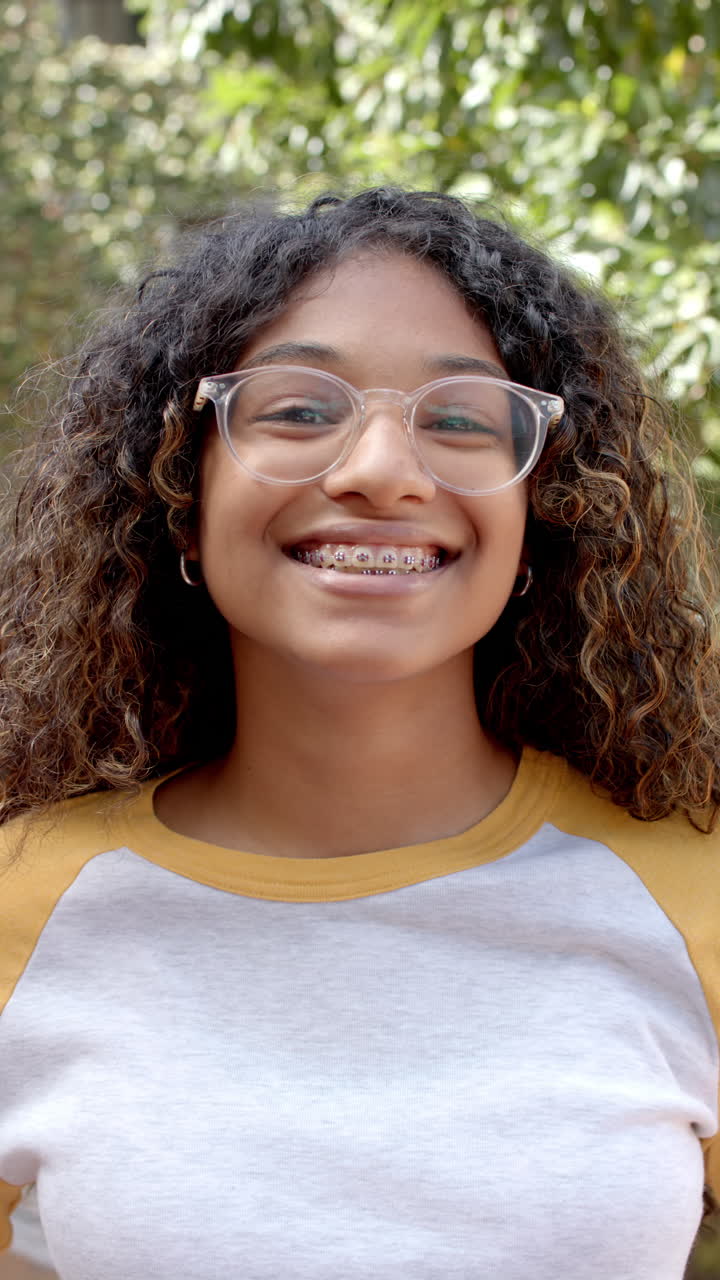 Vertical video: In highschool, young biracial female student is smiling