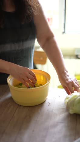 woman washing salad in kitchen