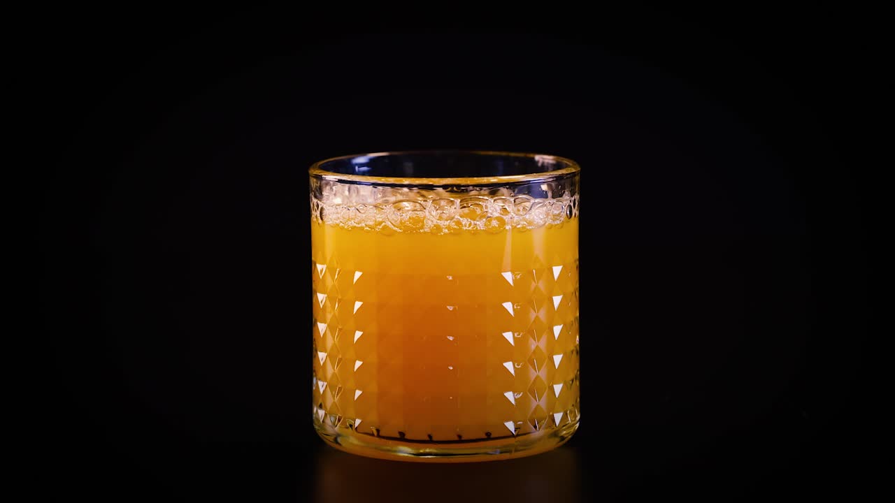 Bicchiere di succo d'arancia su sfondo scuro