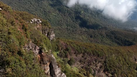 Drone-aerial-push-in-shot-of-Gede-Pangrango-mountain-slopes-and-jungle-or-forest-with-huge-cloud-at-the-background-almost-touching-the-mountain