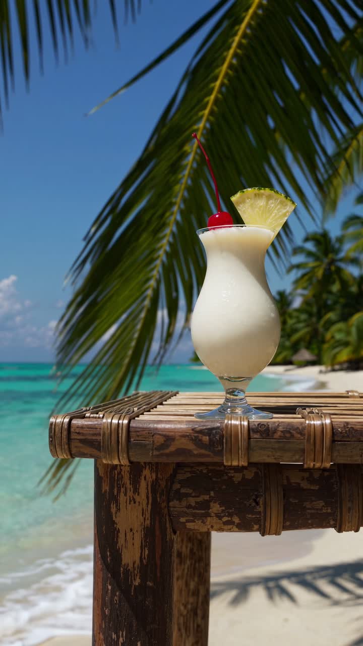 Tropical paradise video concept with a low-angle shot of a pina colada on a rustic table, framed