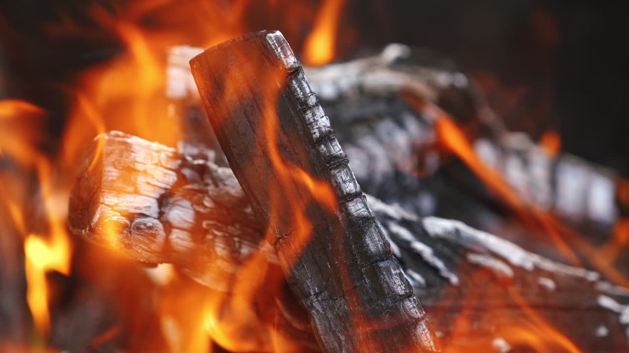 Falò nella natura, primo piano. Sfondo caldo e suggestivo con fiamma arancione di un falò