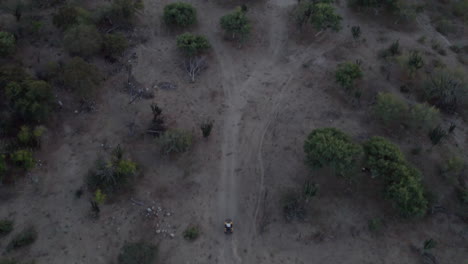 Man-riding-a-motorcycle-in-a-dirt-road