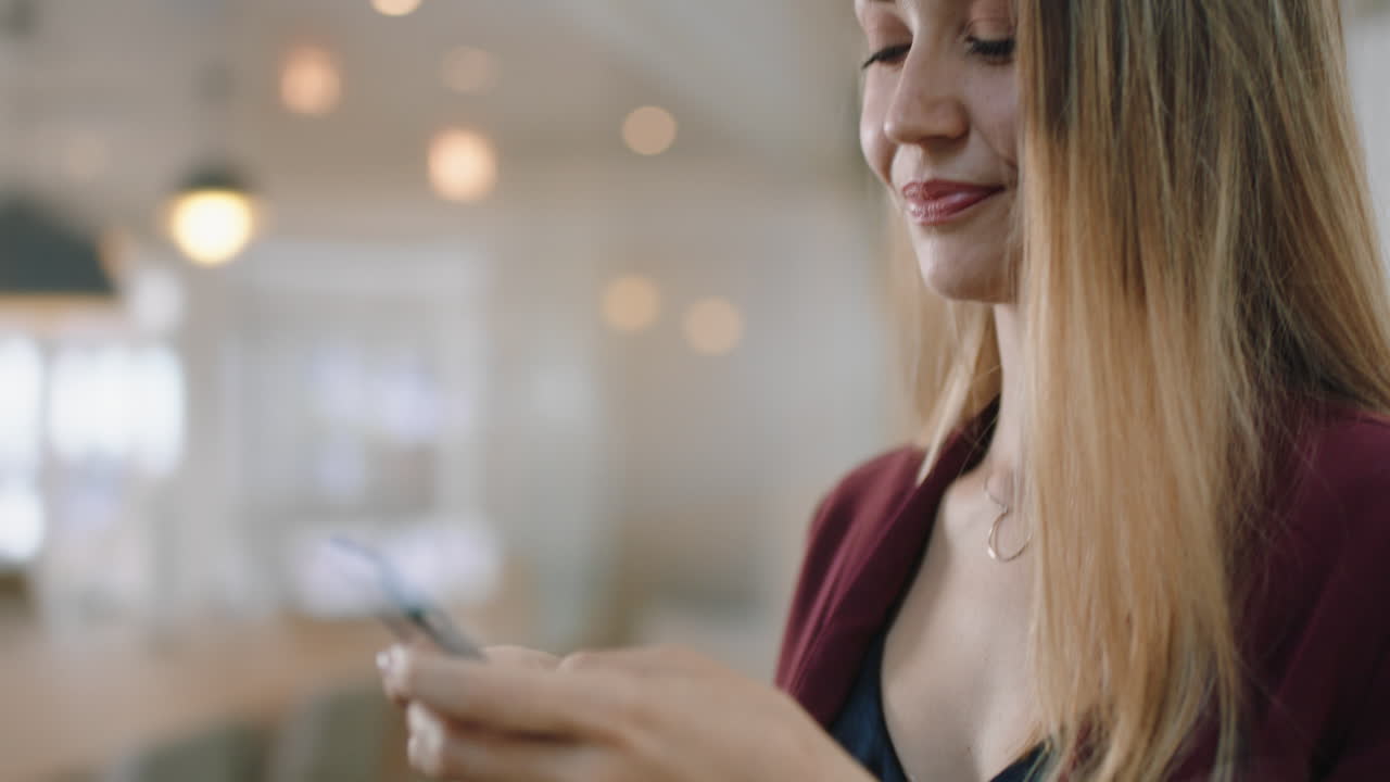 bella donna d'affari bionda che usa lo smartphone in ufficio che manda messaggi di testo che invia e-mail che pianifica riunioni che fa networking online che naviga i messaggi sulla tecnologia del telefono cellulare 4k