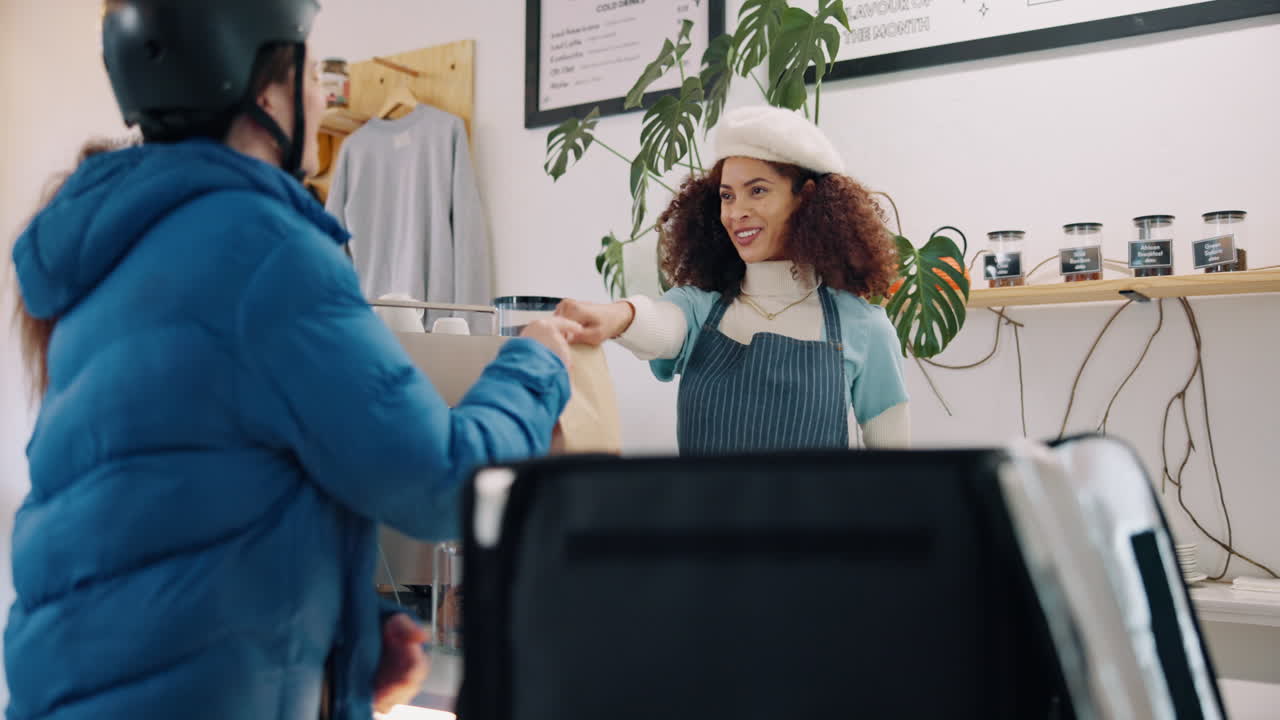 A woman on a bike picks up a delivery from a cafe