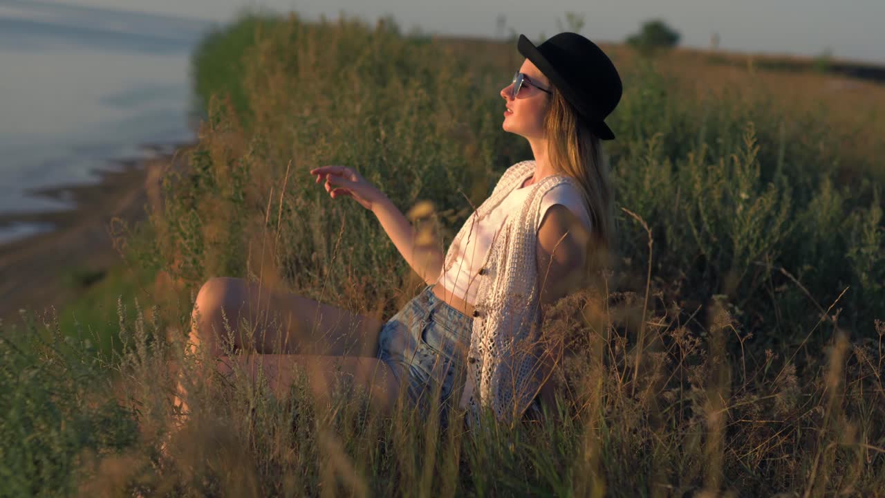 mujer relajándose en un campo al atardecer