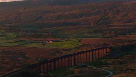 estableciendo una toma aérea de drones del viaducto de ribblehead al atardecer con la montaña whernside detrás en yorkshire dales, reino unido