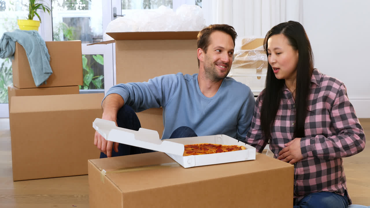 Couple having pizza in new house 4k