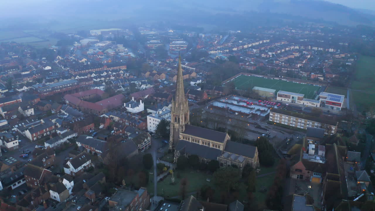 una toma aérea sobrevolando una antigua iglesia inglesa en dorking, surrey, en una mañana nublada