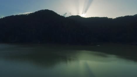 afternoon drone shot of lake water and reflections revealing clouds and light rays
