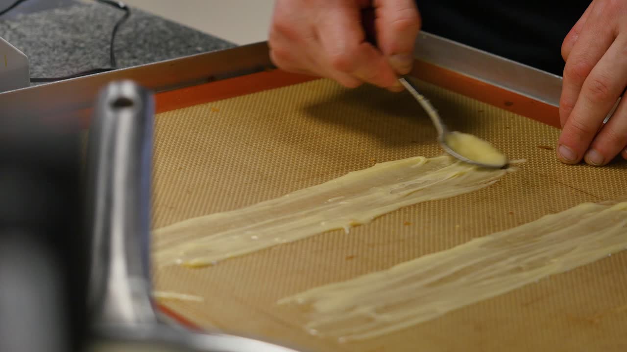 요리사 가 베이킹 시트 에 페이스트리 반죽 을 준비 하고 있다