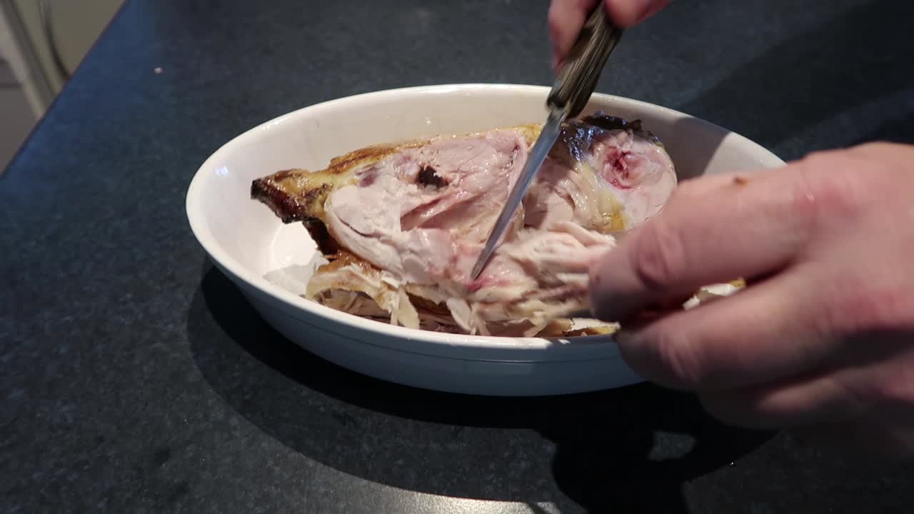 Man cutting or carving a hot roast chicken