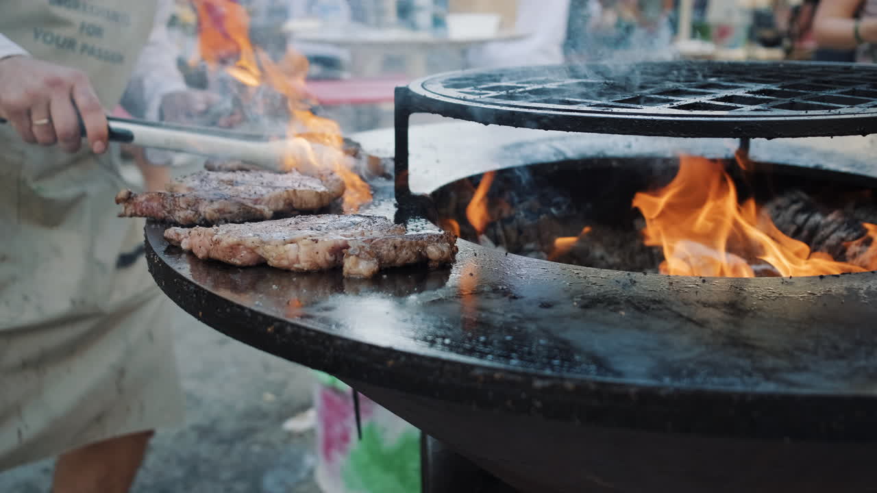 셰프가 야외에서 스테이크를 고 있습니다.