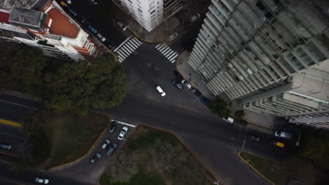 A-complicated-intersection-in-Buenos-Aires,-a-drone-descends-to-its-center,-cars-in-the-middle-of-the-track