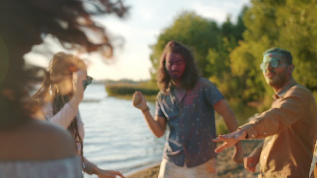 화려한 페인트로 더러운 창의적인 청소년이 홀리 축제 축하 기간 동안 해변에서 야외에서 춤을 추고 있습니다.