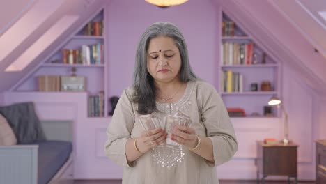 una anciana india contando dinero.