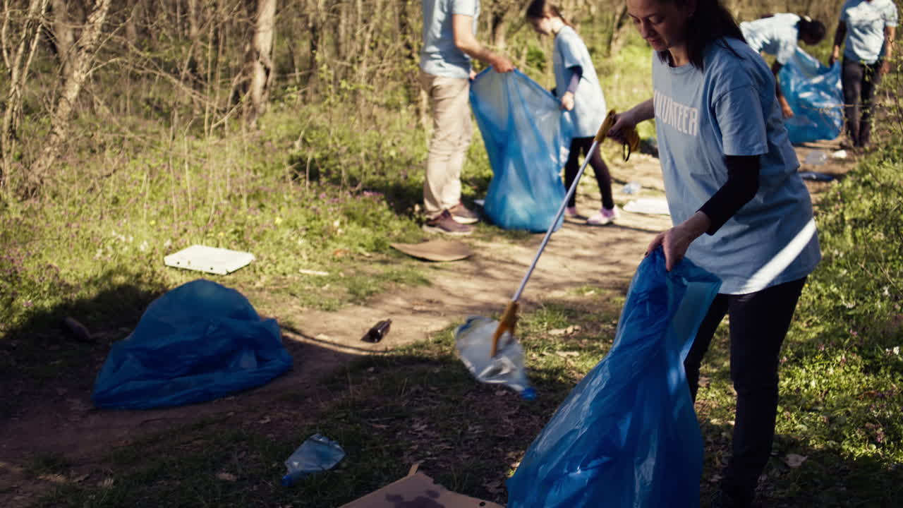Environmental activist picking up trash with a claw tool and recycling