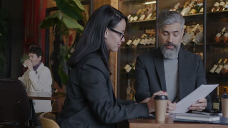 businesspeople discussing documents in a cafe
