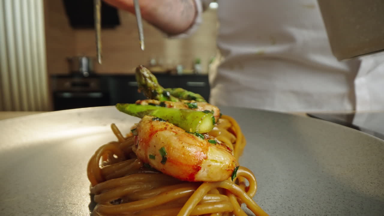 Chef preparing pasta with shrimp and asparagus
