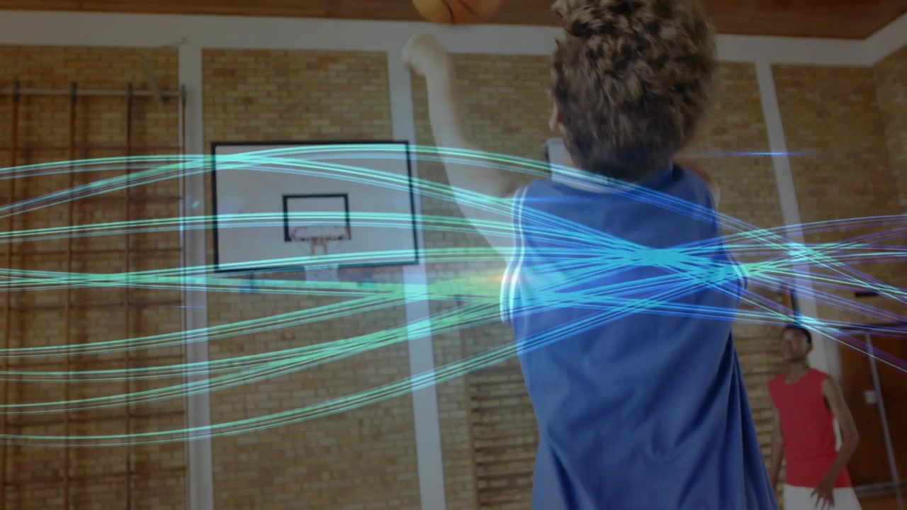Vertical video: Holding ball, kid in blue kit shooting at hoop to score in school gym, teal arcs