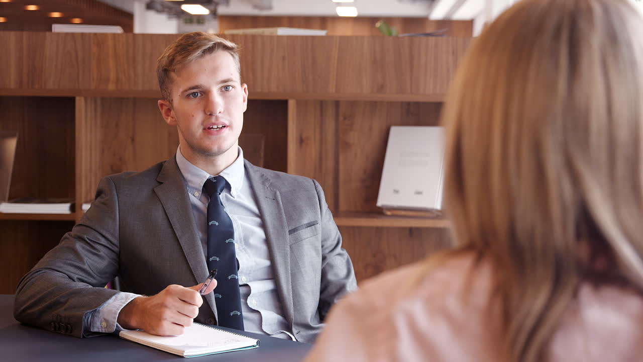 Businessman Interviewing Female Candidate At Graduate Recruitment Assessment Day In Office