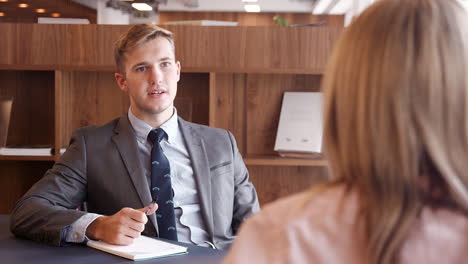 businessman interviewing female candidate at graduate recruitment assessment day in office