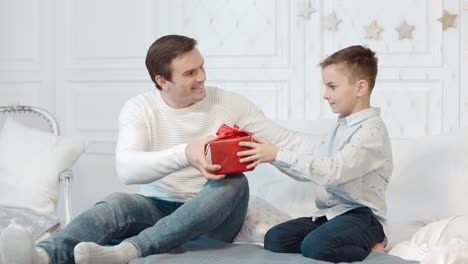 Hijo-Emocionado-Recibiendo-Un-Regalo-Increíble-En-Una-Sala-De-Estar-Decorada-Con-Navidad.