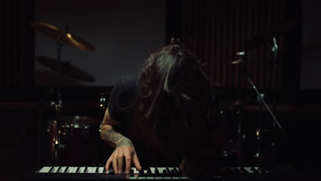 Smiling-man-pressing-keys-in-music-studio.-Excited-guy-playing-keyboard-indoor.