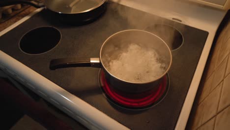 overhead view of eggs boiling on stove top