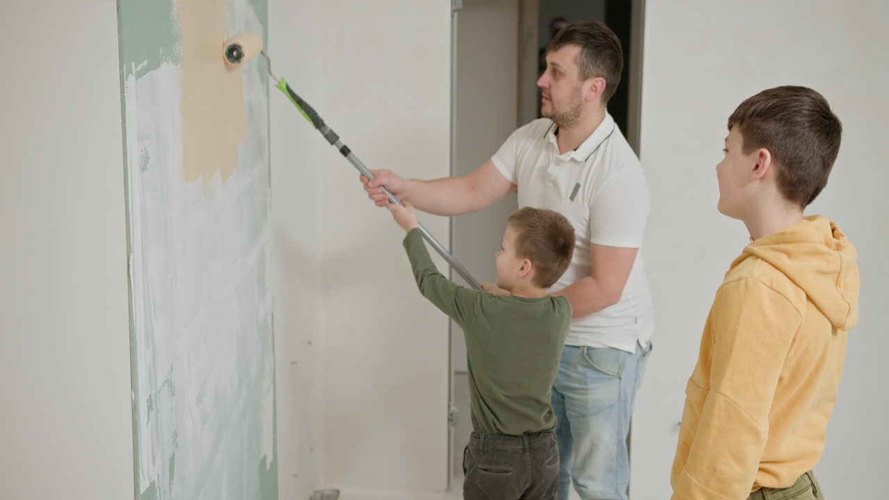 padre e hijos pintando una pared