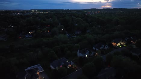 quiet american neighborhood at night. lighting houses and lanterns along street. slow flyover houses and homes in american suburb of pennsylvania. aerial rising establishing wide shot.