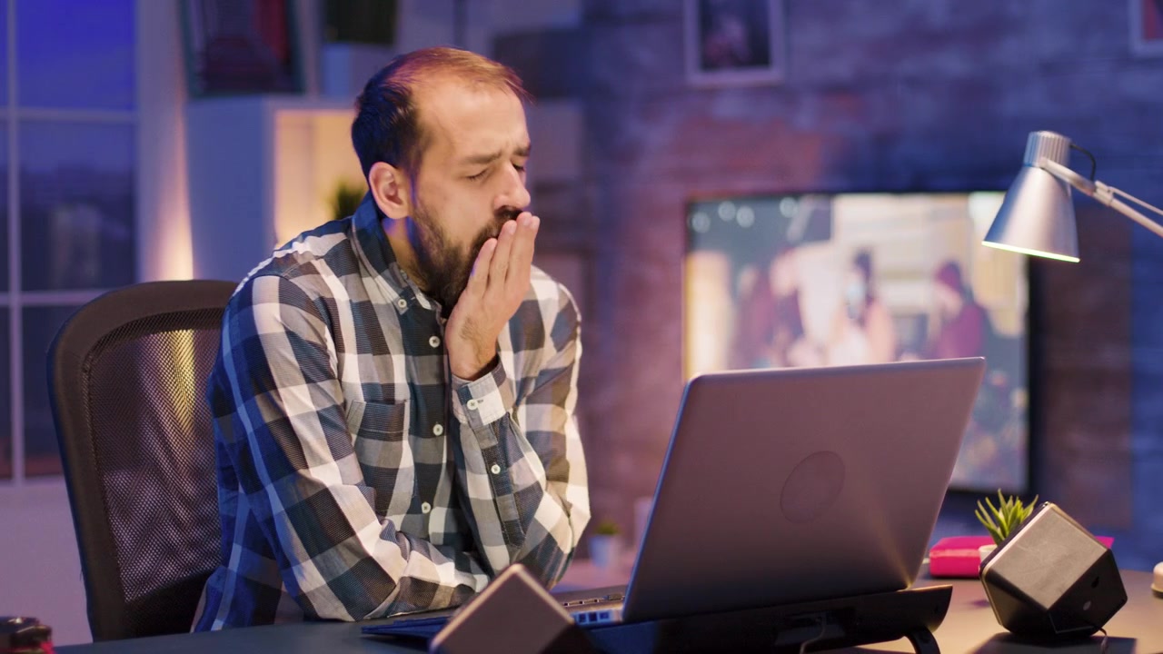 Tired Man Working Late at Night on Laptop