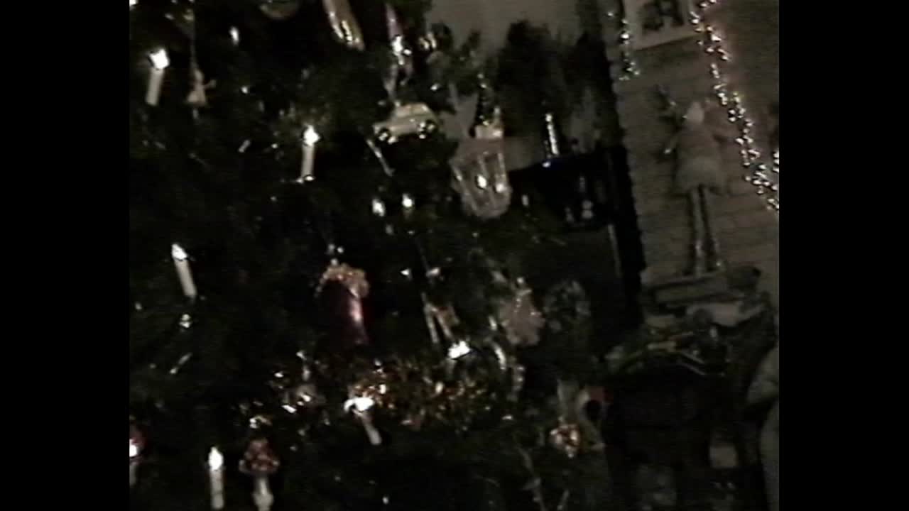Girl decorating Christmas tree in nostalgic VHS video