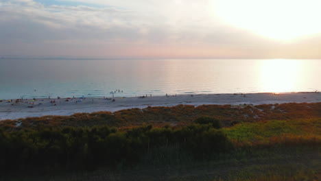 Draufsicht-Des-Klicks-Mit-Blick-Auf-Eine-Gruppe-Von-Menschen-Am-Strand,-Die-Sich-Am-Abend-Entspannen-Und-Genießen,-Wenn-Meereswellen-Das-Ufer-Des-Dorfes-Portovenere-In-Italien-Berühren