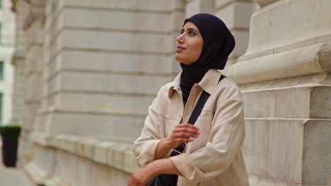 muslim businesswoman wearing hijab and modern business suit standing outside city office buildings 1