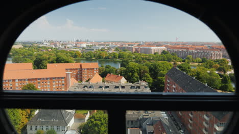 Blick-Auf-Die-Stadt-Kopenhagen-Durch-Das-Antike-Runde-Fenster-Des-Schraubenturms-4k-Video