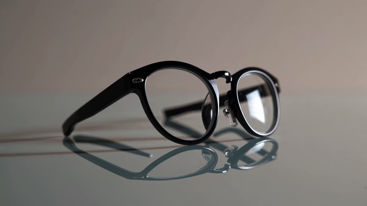 Minimalist video concept of black glasses on a reflective surface