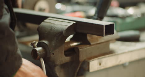 hombre que trabaja en la industria metalúrgica cortando y midiendo piezas metálicas en el taller 5