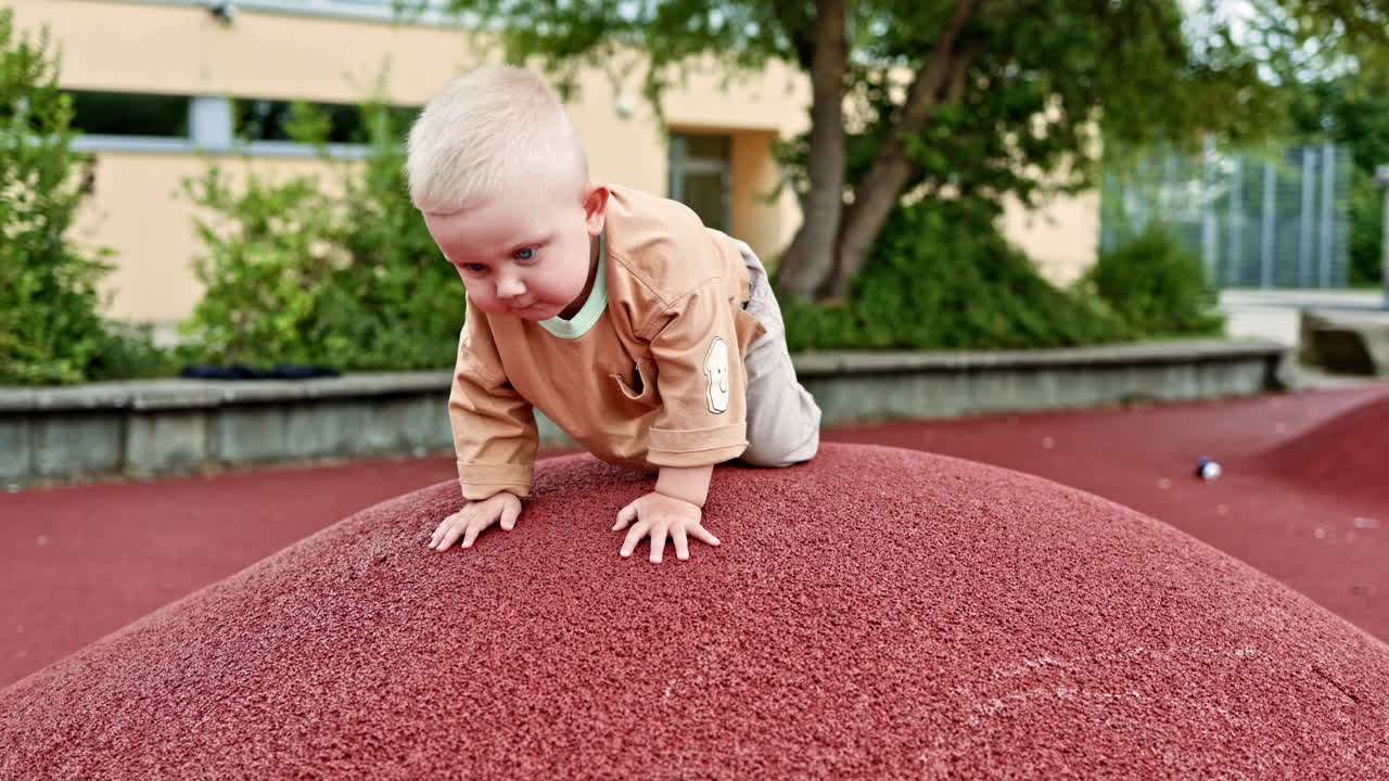Un bambino vivace corre sulle colline del parco giochi. Il bambino corre e respira l'aria fresca. Il bambino in jeans e maglietta gioca all'aperto.